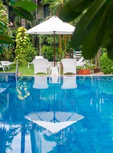 um guarda-sol e cadeiras numa piscina em Lokal Phuket "Former K-Hotel" - SHA Extra Plus em Patong Beach