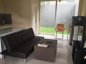 a living room with a black couch and a table at House at Taman Dayu in Pasuruan