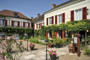 a group of buildings with flowers in front of them at Logis Hôtel Auberge De L'ecole in Pontlevoy