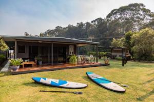 two surfboards sitting on the grass in front of a house at Rocketz at Berrara Beach in Sussex inlet