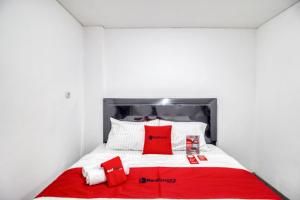 a bed with red and white pillows on it at RedDoorz Syariah near Galeria Mall Yogyakarta in Yogyakarta