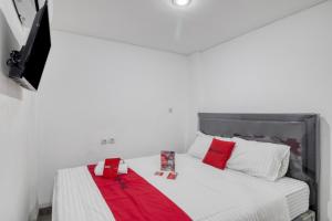 a bedroom with a bed with red and white pillows at RedDoorz Syariah near Galeria Mall Yogyakarta in Yogyakarta +7 photos