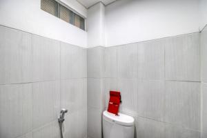 a bathroom with a red box on top of a toilet at RedDoorz Syariah near Galeria Mall Yogyakarta in Yogyakarta