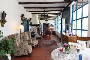 a living room with couches and a table at Hotel Boutique Casa de Hacienda Su Merced in Puembo