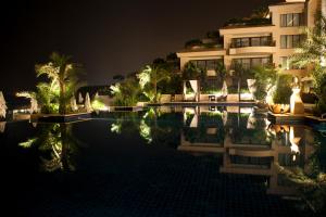 un hotel de noche con su reflejo en el agua en Vivanta Surajkund, NCR en Faridabad