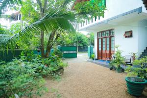a courtyard of a house with a palm tree and plants at Ananda Villa Bentota in Bentota