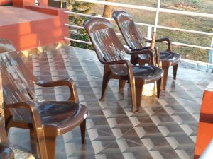 Leon Hide Out Guest House في فاسكو دا غاما: مجموعة من الكراسي على الشرفة