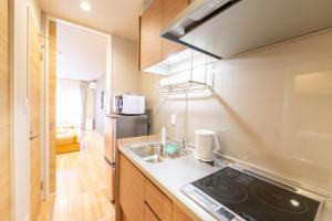 a kitchen with a sink and a stove at GRAND BASE Hiroshima Hikarimachi in Hiroshima