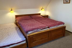 a bedroom with two beds and two lights on the wall at Selský dvůr 2 in Police nad Metují