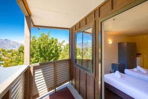 a room with two beds and a balcony with a view at Reavers Lodge in Queenstown