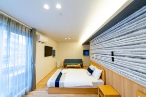 A bed or beds in a room at GRAND BASE Hiroshima Hikarimachi