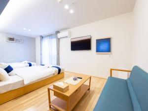 広島市にあるグランドベース広島光町のベッドとソファ付きのホテルルーム