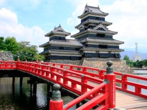 a red bridge in front of two tall buildings at Hakuraiso in Matsumoto +19 photos