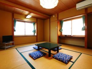 a room with a ping pong table and two pillows at Hakuraiso in Matsumoto