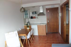 a kitchen with a wooden table and a table and chairs at Apartament - Monte Oiz - 2/4 pax + parking in Sierra Nevada
