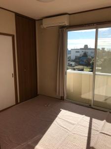 una stanza vuota con una grande finestra e un balcone di Akira Heights a Ōta