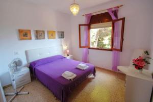 1 dormitorio con cama morada y ventana en Condelmar - modern villa close to the beach in Calpe, en Calpe