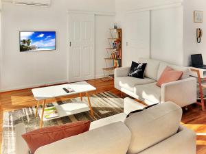 a living room with a couch and a table at Glen Iris, Quiet Boutique 2 bedroom Netflix, WIFI, Parking, Free Wine in Melbourne
