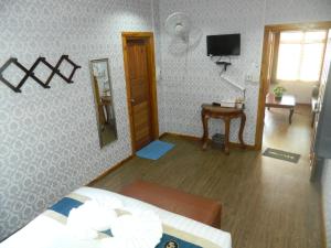 - une chambre avec un lit, un miroir et une télévision dans l'établissement Pai Iyara Resort, à Pai