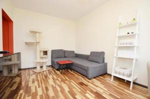 a living room with a couch and a wooden floor at Stronska in Wrocław