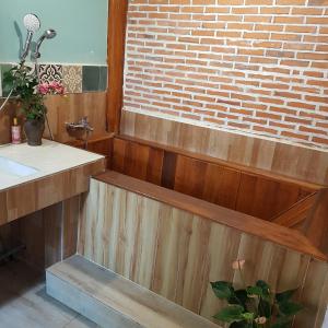 a bathroom with a sink and a brick wall at Tien Yoga House in Cái Bè