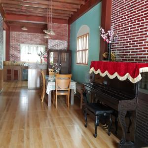 a living room with a piano and a table with chairs at Tien Yoga House in Cái Bè