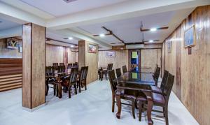 una sala da pranzo con pareti e tavoli in legno e sedie di Treebo Trend Lake Bloom Powai a Mumbai