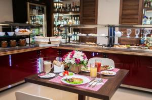 a table with two plates of food and drinks at Hotel Milot in Volzhskiy