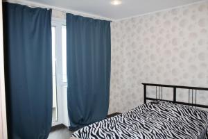 モスクワにあるLoft na jubilee 40-2のベッドルーム1室(青いカーテン、窓付)