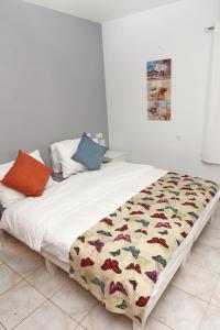 a large white bed with a colorful blanket on it at Yaeli's Yam Souf in Eilat