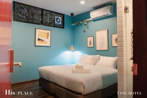 1 dormitorio con 1 cama con pared azul en Tang House, en Bangkok