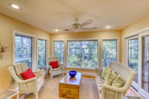 a living room with chairs and a table and windows at Inlet Cove 12 in Kiawah Island