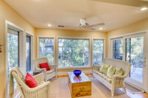 a living room with chairs and a table and windows at Inlet Cove 12 in Kiawah Island