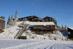 um edifício sobre uma colina coberta de neve com um comboio em Kvitfjell Alpinhytter Kvitfjellvegen 492 em Kvitfjell