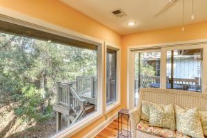 a screened in porch with a couch and two large windows at Inlet Cove 12 in Kiawah Island