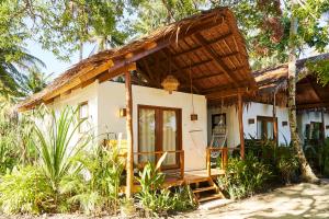 a small white house with a thatched roof at G Villas Siargao in General Luna