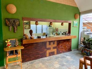 a woman sitting at a counter in a restaurant at Hôtel Amédzépé in Palimé