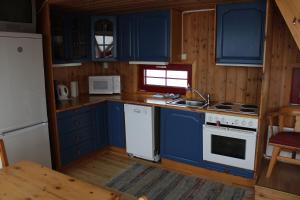 a kitchen with blue cabinets and a white stove top oven at Kvitfjell Alpinhytter Kvitfjellvegen 492 in Kvitfjell