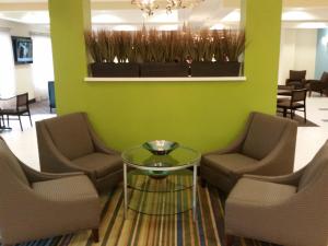 una sala de espera con sillas y una mesa de cristal en Holiday Inn Express and Suites Atascocita - Humble - Kingwood, an IHG Hotel, en Humble