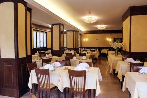 a dining room with tables and chairs with white tablecloths at Hotel Sporting in Roccaraso