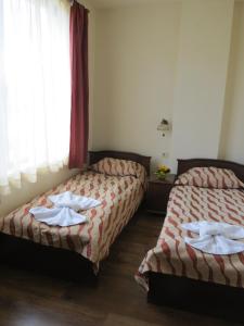 two beds sitting next to each other in a room at Apartments & Studios Mountain Romance in Bansko