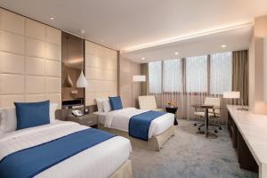 um quarto de hotel com duas camas e uma secretária em Grand Palace Hotel em Yangon