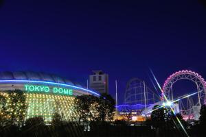 a tiki dome and a roller coaster at night at the b ikebukuro in Tokyo