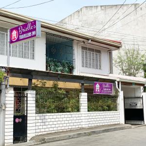 a building with purple signs on the side of it at Brielles Travellers Inn in Tagbilaran City