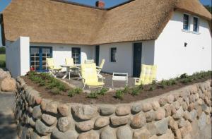 una pared de piedra frente a una casa en Ferienhaus Deichgraf, en Vollerwiek