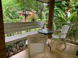 a balcony with a table and two chairs and a table at Khao Yai Cottage in Mu Si
