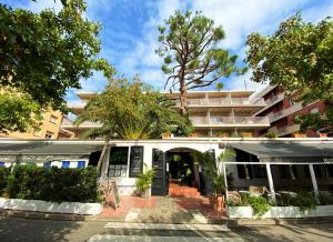 a building with a courtyard with trees in front of it at Hotel Vostra Llar in Palamós
