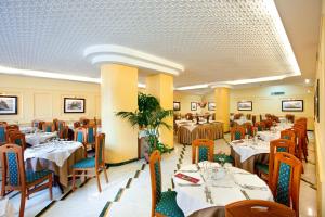 - un restaurant avec des tables et des chaises dans une salle dans l'établissement Hotel Villa Maria, à Sorrente