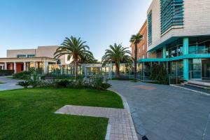 a courtyard with palm trees and a building at Victoria Terme Hotel in Tivoli Terme