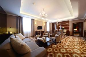 a large living room with a couch and a table at LOTTE City Hotels Tashkent Palace in Tashkent